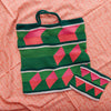 Crocheted bag with pink and green pattern on a pink textured surface