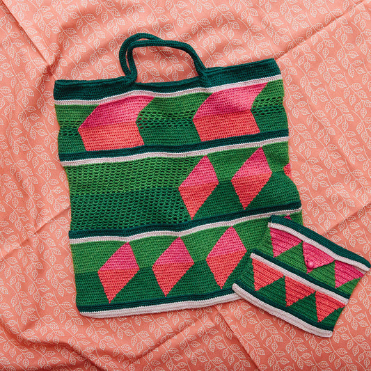 Crocheted bag with pink and green pattern on a pink textured surface