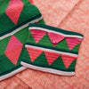 Crocheted green and pink patterned bag on a pink fabric background