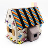 Crocheted toy house with a colorful striped roof on a white background