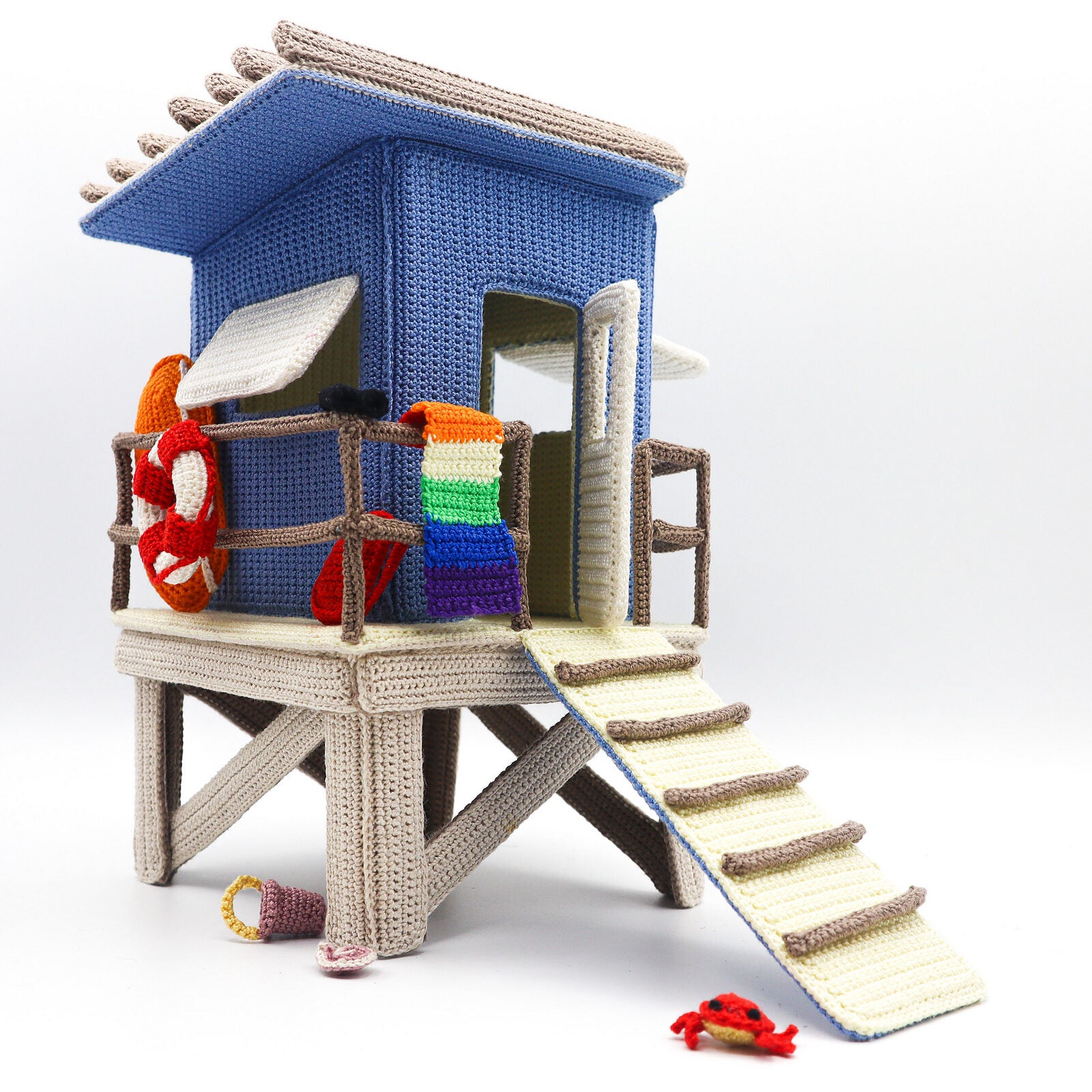Crocheted lifeguard tower with colorful accents on a white background